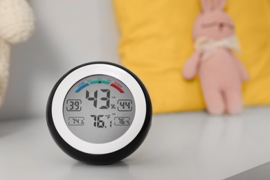 Photo of Digital hygrometer with thermometer on white table. Space for text