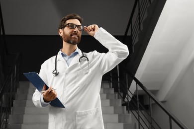 Photo of Doctor with stethoscope and clipboard in hospital