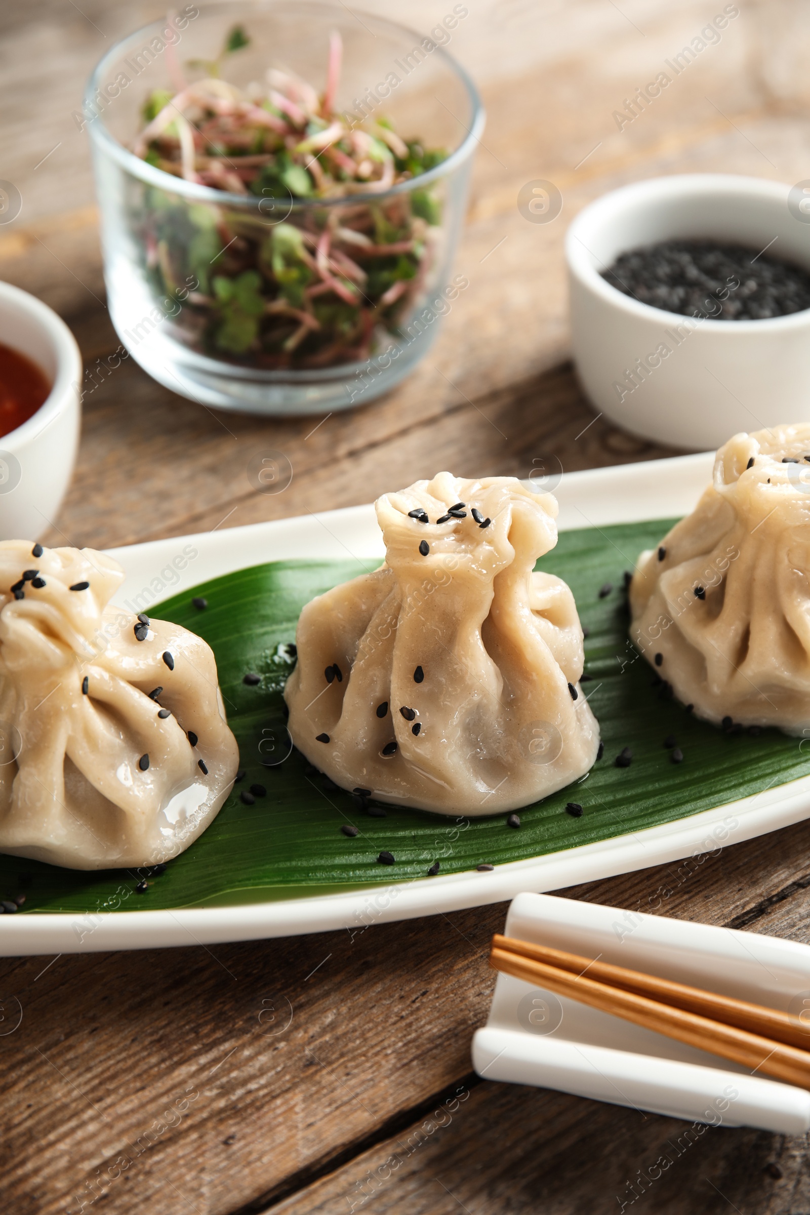 Photo of Plate with tasty baozi dumplings on table, closeup