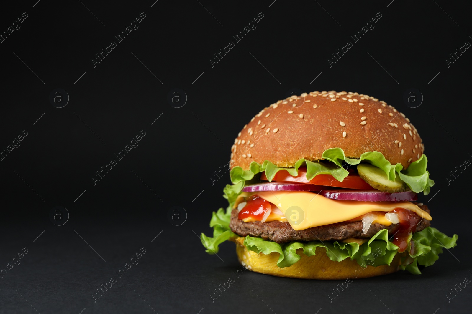 Photo of Delicious burger with beef patty and lettuce on dark background, space for text