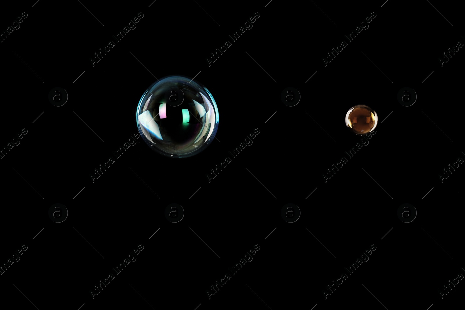 Photo of Beautiful translucent soap bubbles on dark background