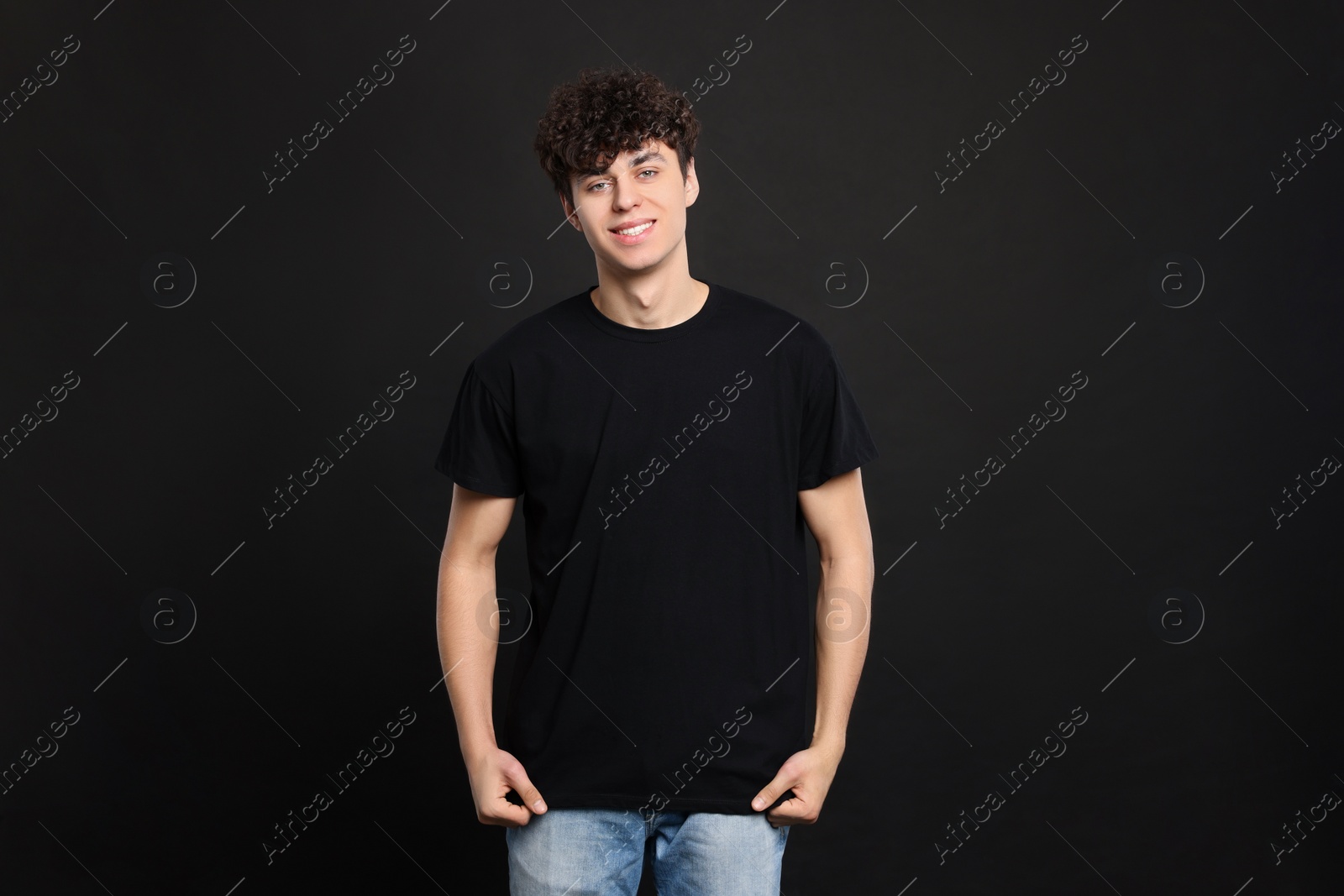 Photo of Man wearing stylish t-shirt on black background. Mockup for design