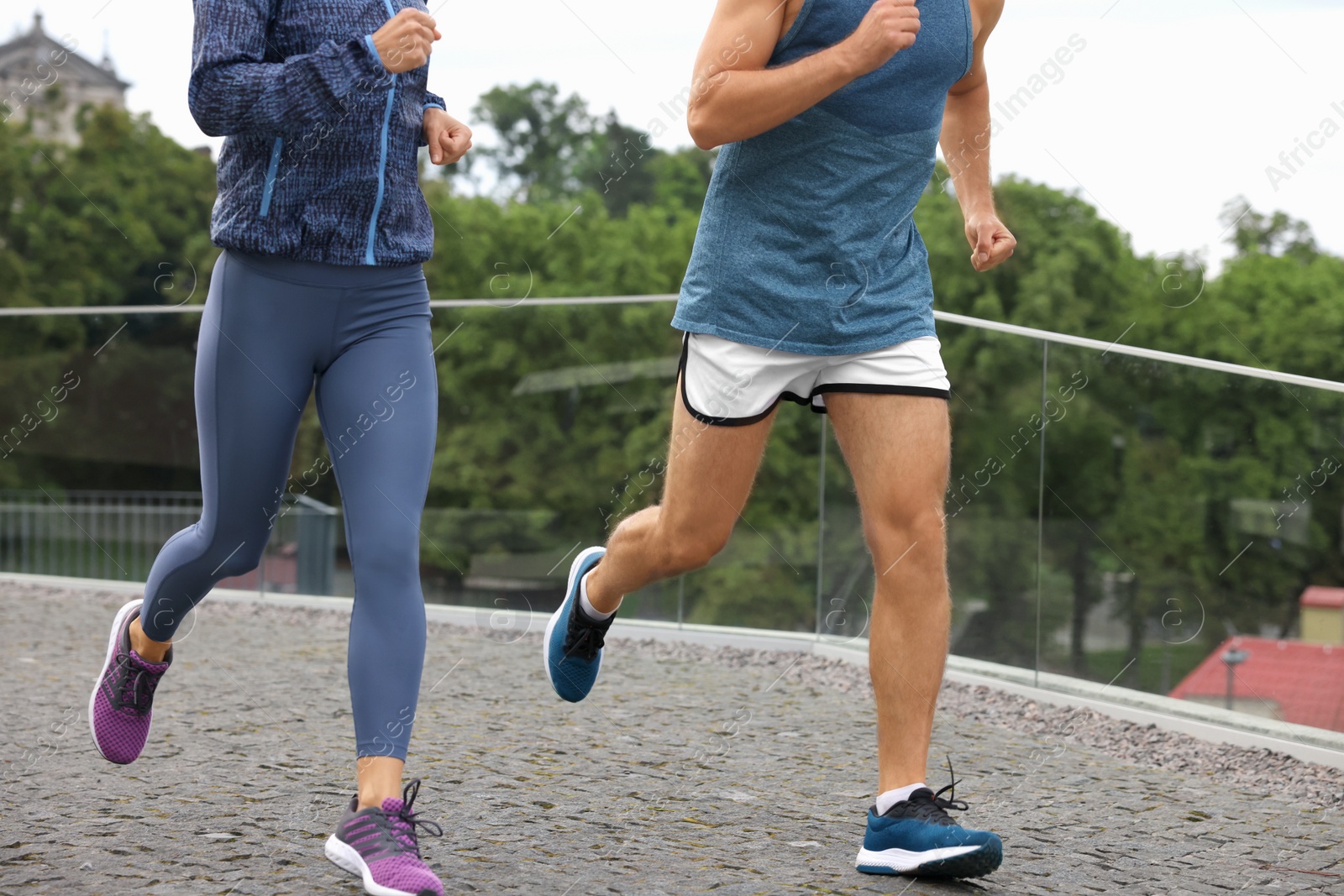 Photo of Healthy lifestyle. Sporty couple running outdoors, closeup