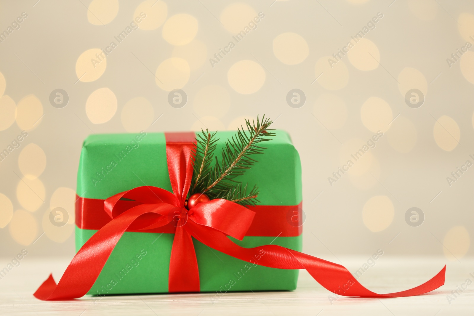 Photo of Christmas gift on wooden table against blurred lights