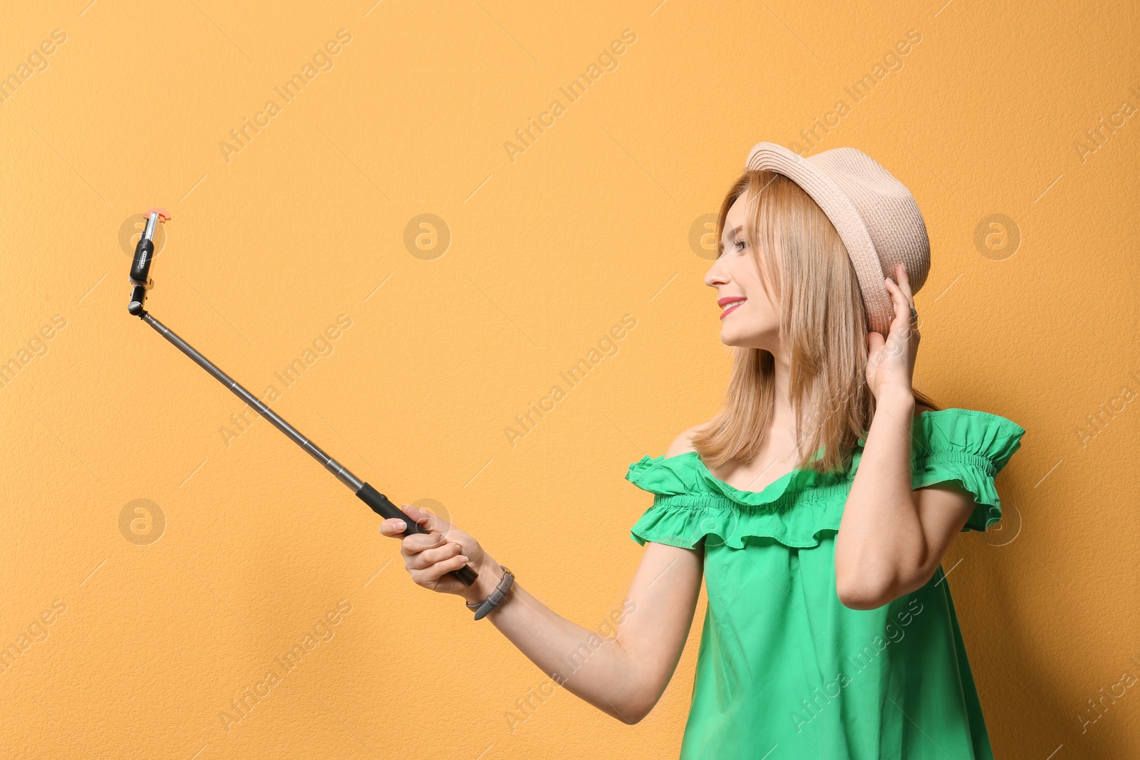 Photo of Attractive young woman taking selfie on color background