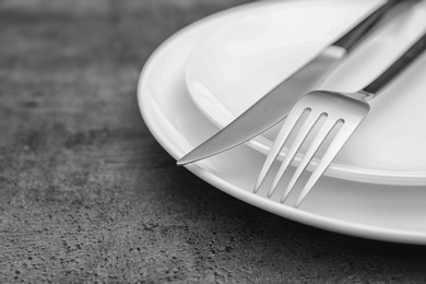 Photo of Empty dishware and cutlery on gray background, close up view. Table setting