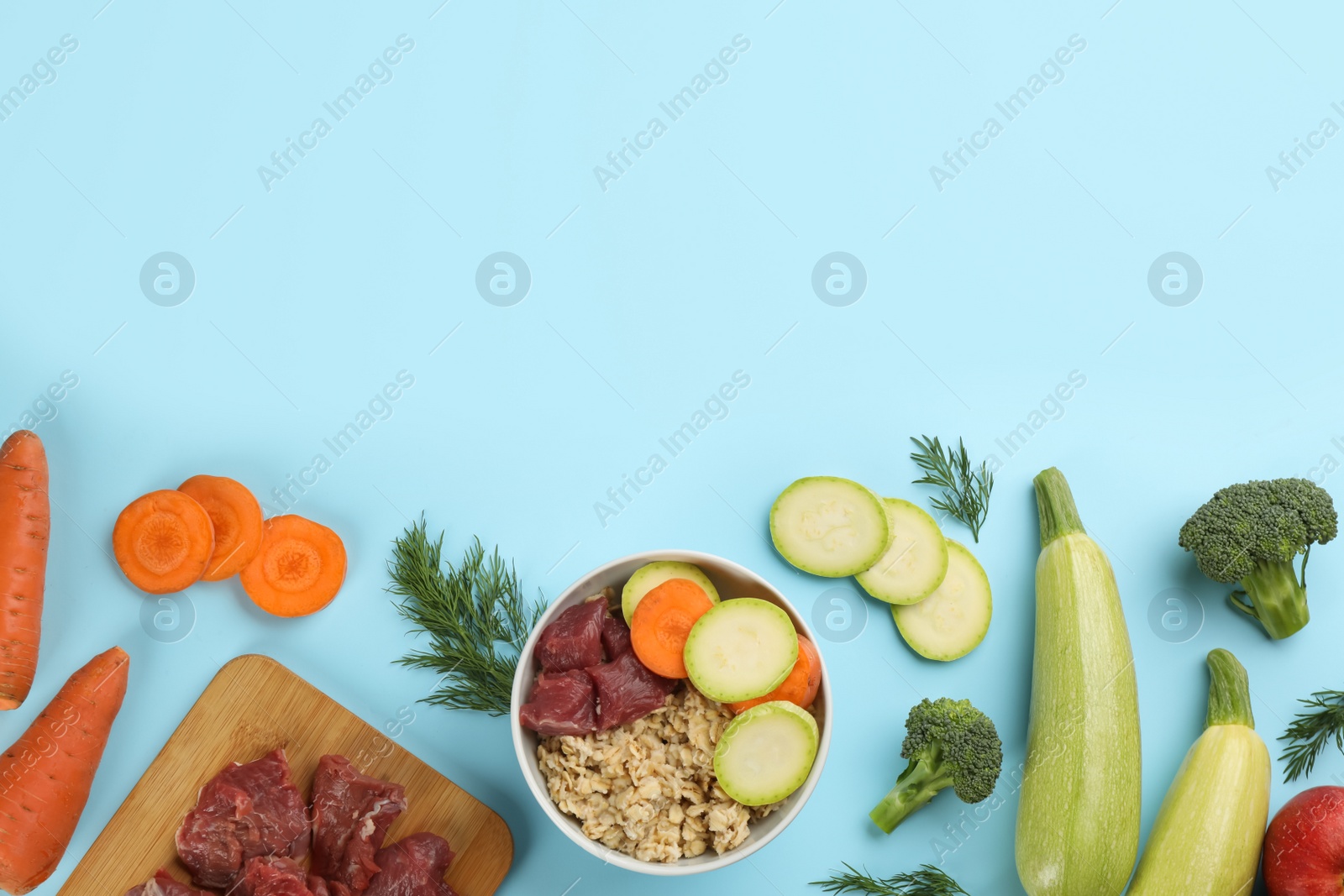 Photo of Pet food and natural ingredients on light blue background, flat lay. Space for text