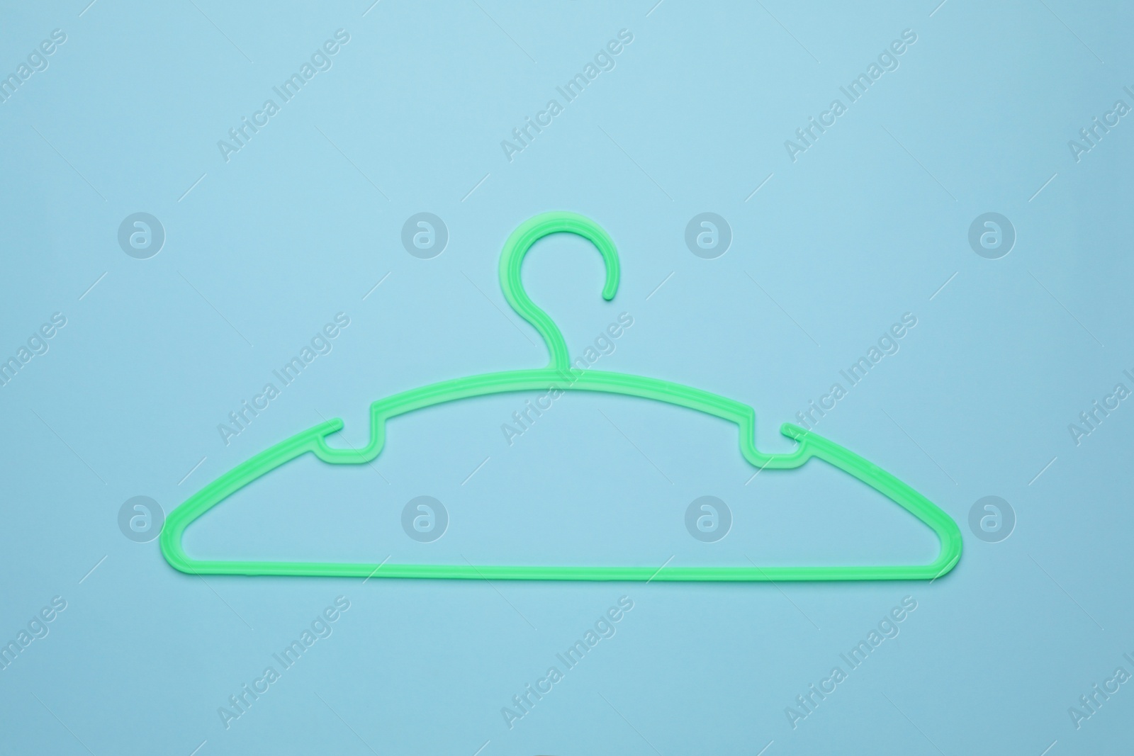 Photo of Empty clothes hanger on light blue background, top view