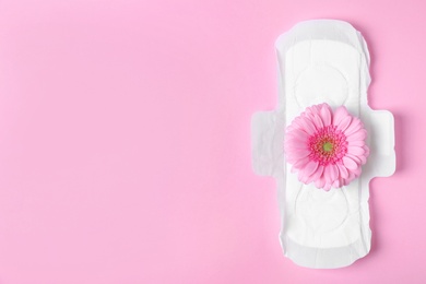 Photo of Menstrual pad and flower on color background, top view with space for text. Gynecological care