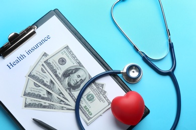 Photo of Flat lay composition with medical insurance form, money, heart and stethoscope on blue background