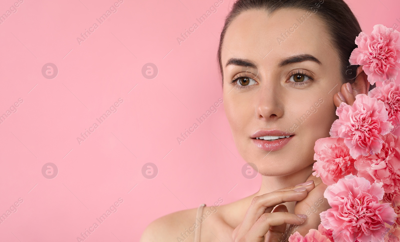 Image of Beautiful woman with smooth skin and flowers on pink background. Space for text