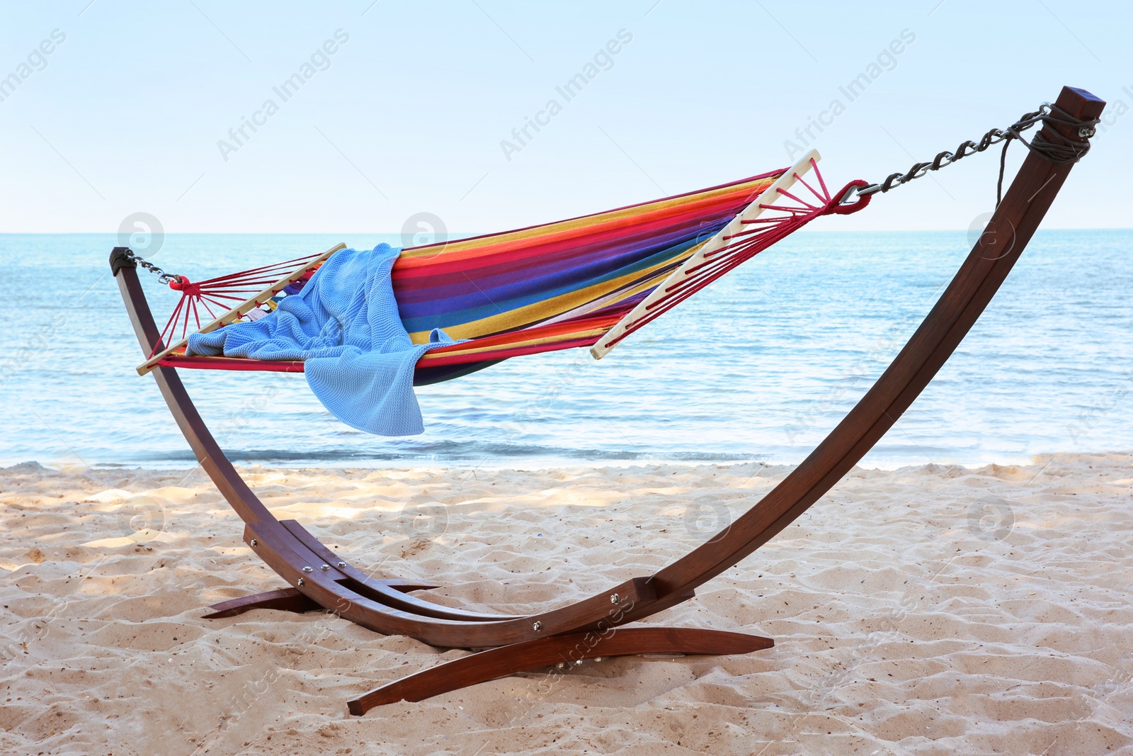 Photo of Colorful hammock with blanket at seaside. Summer vacation