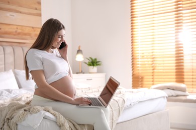 Photo of Pregnant woman working on bed at home, space for text. Maternity leave