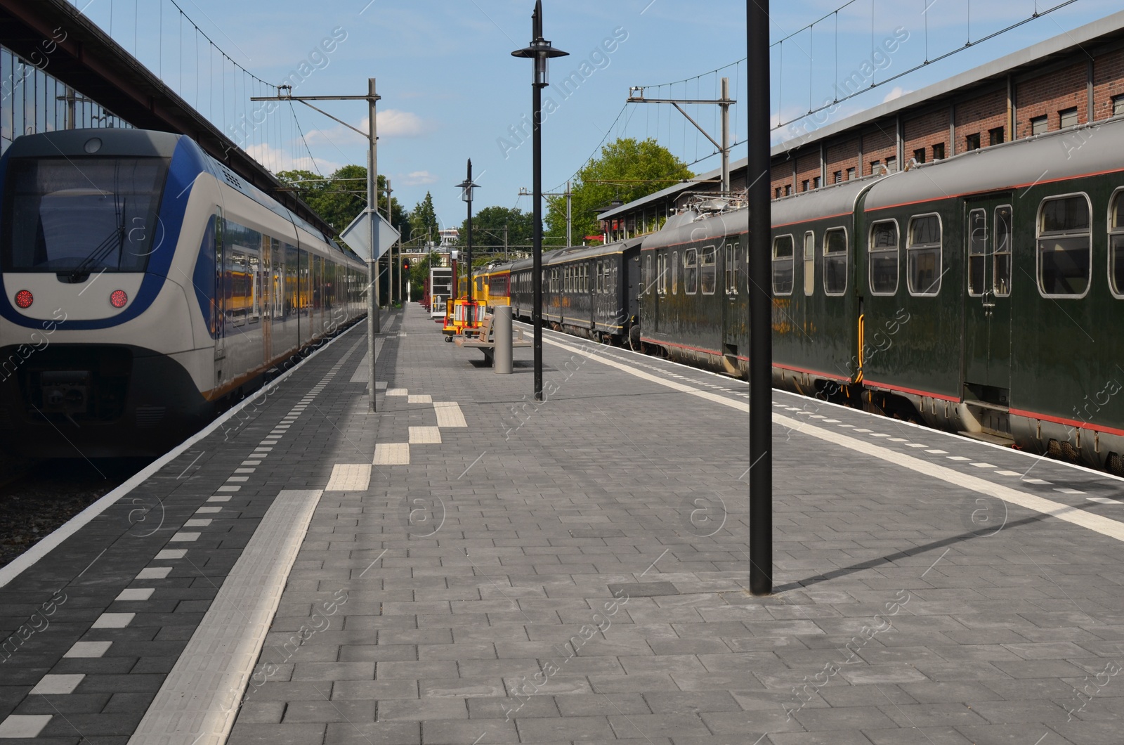 Photo of Modern trains at railway station on sunny day