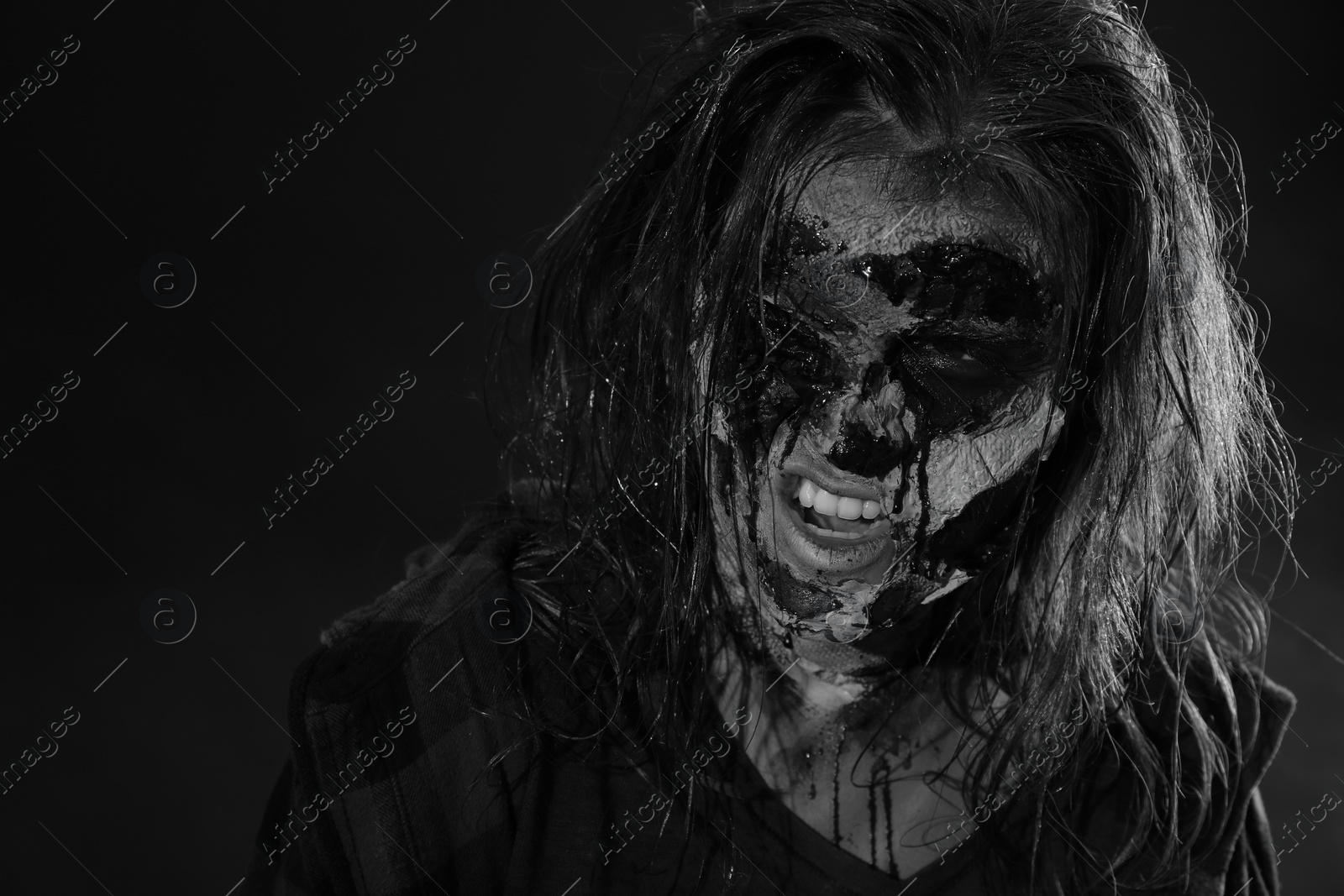 Photo of Scary zombie on dark background, black and white effect. Halloween monster