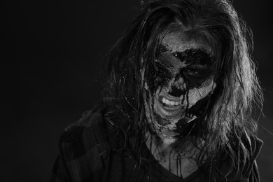 Photo of Scary zombie on dark background, black and white effect. Halloween monster