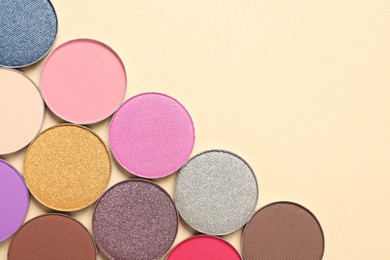 Different beautiful eye shadows on beige background, flat lay. Space for text