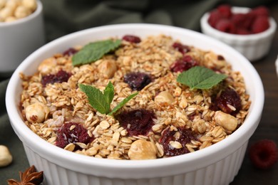 Photo of Tasty baked oatmeal with berries and nuts on table, closeup