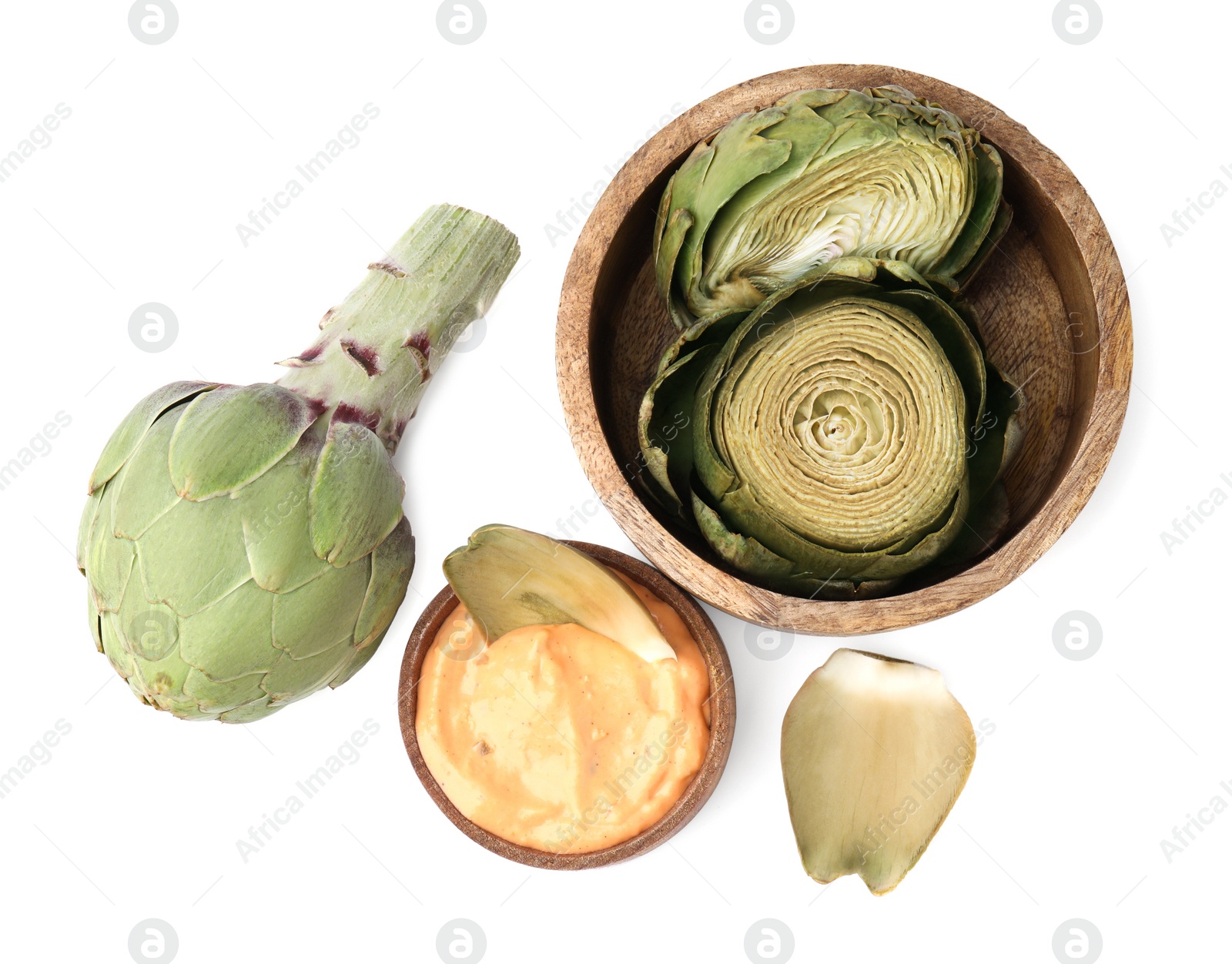 Photo of Delicious cooked artichoke with tasty sauce and fresh vegetable isolated on white, top view