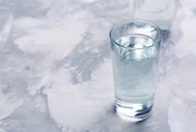 Photo of Glass with fresh water on table. Space for text
