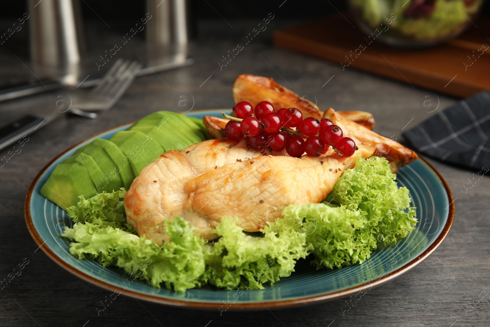 Photo of Tasty cooked chicken fillet and vegetables served on grey table. Healthy meals from air fryer