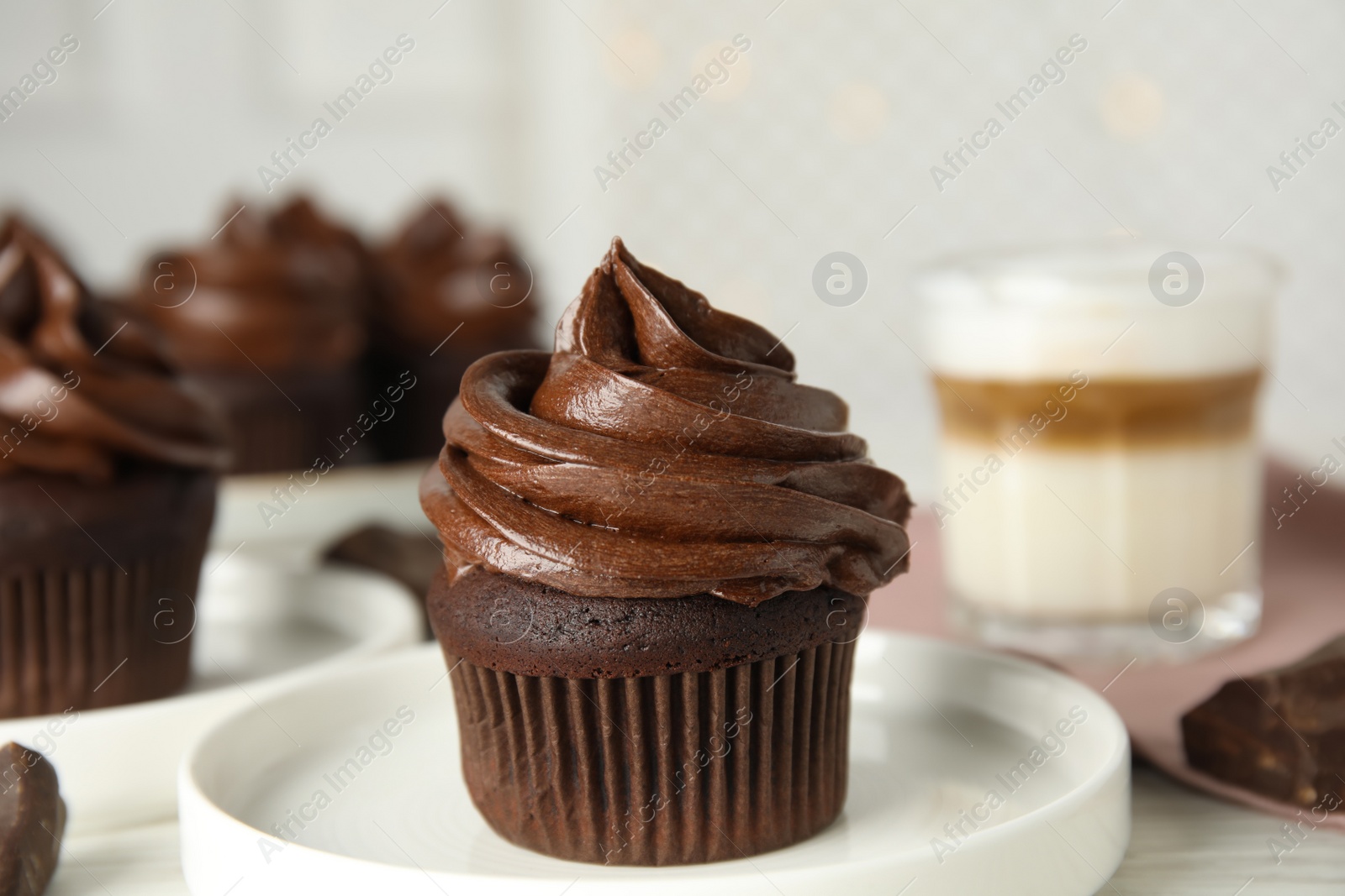 Photo of Plate with delicious chocolate cupcake on white table