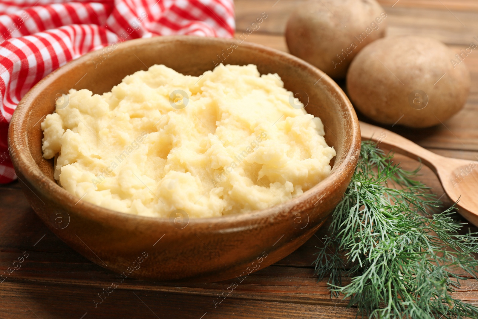 Photo of Bowl with tasty mashed potatoes on wooden table