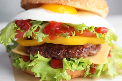 Photo of Closeup view of tasty burger with fried egg