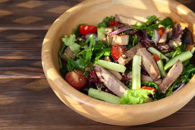 Delicious salad with beef tongue and vegetables on wooden table, closeup