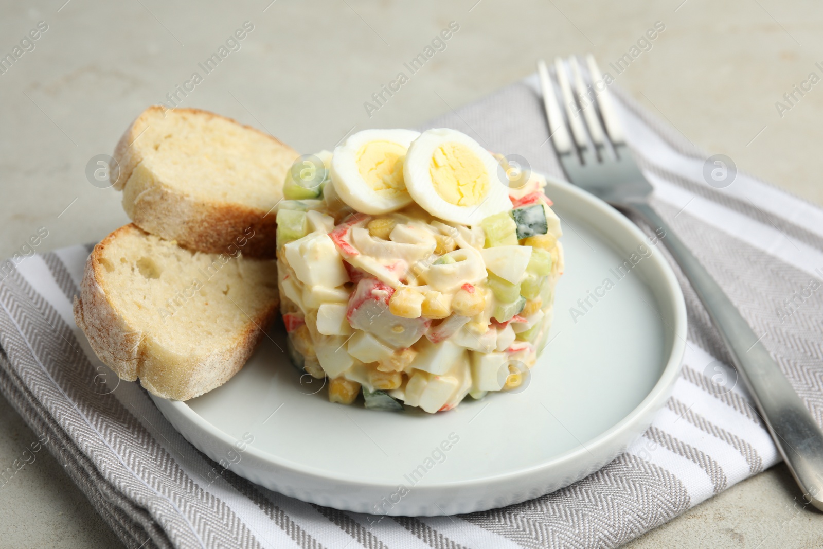 Photo of Delicious salad with crab sticks and eggs on grey table, closeup