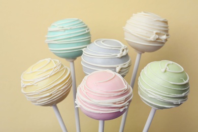 Photo of Sweet colorful cake pops on yellow background