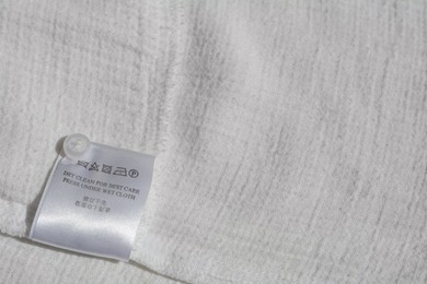 Photo of Clothing label with instruction on white garment, space for text