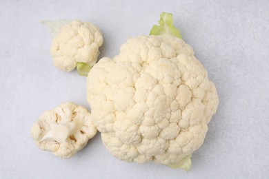 Photo of Cut fresh raw cauliflower on light grey table, flat lay