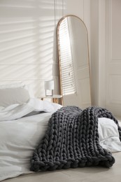 Photo of Soft chunky knit blanket on bed in room