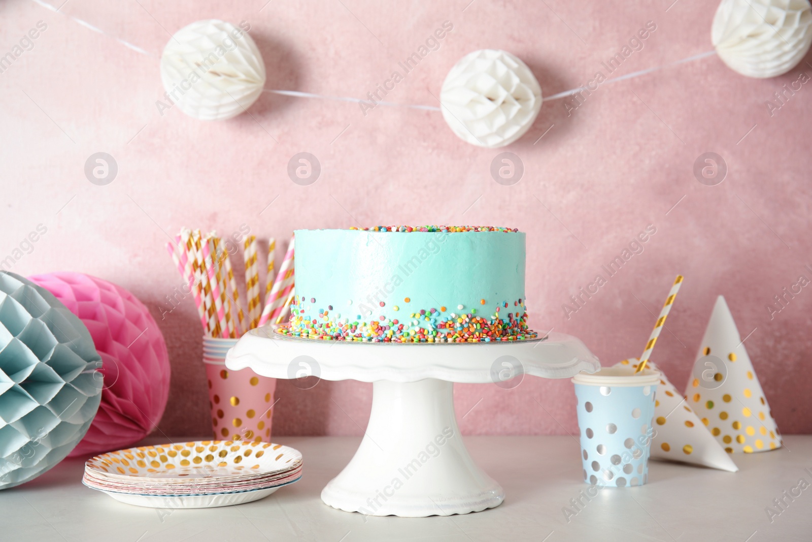 Photo of Stand with fresh delicious cake and birthday decorations on table