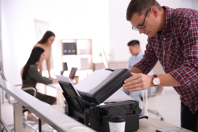 Photo of Employee using new modern printer in office