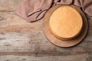 Delicious fresh homemade cake and napkin on wooden table, flat lay. Space for text