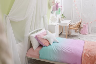 Photo of Cute child's room interior with bed and comfortable workplace