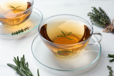 Photo of Aromatic herbal tea with thyme and rosemary on white table