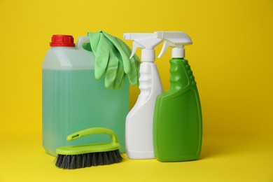 Photo of Cleaning supplies and tools on yellow background