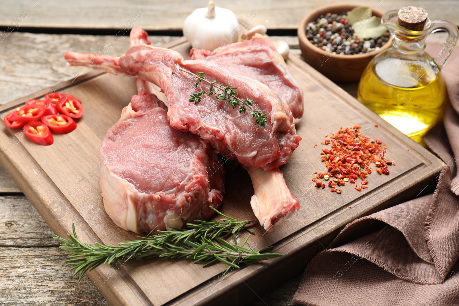 Photo of Fresh tomahawk beef cuts and spices on wooden table, closeup