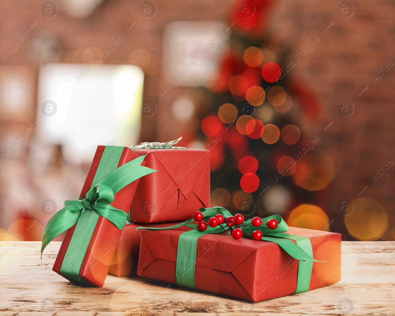 Image of Christmas gift boxes on wooden table in room, bokeh effect