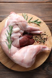 Whole raw rabbit, liver and spices on wooden table, top view