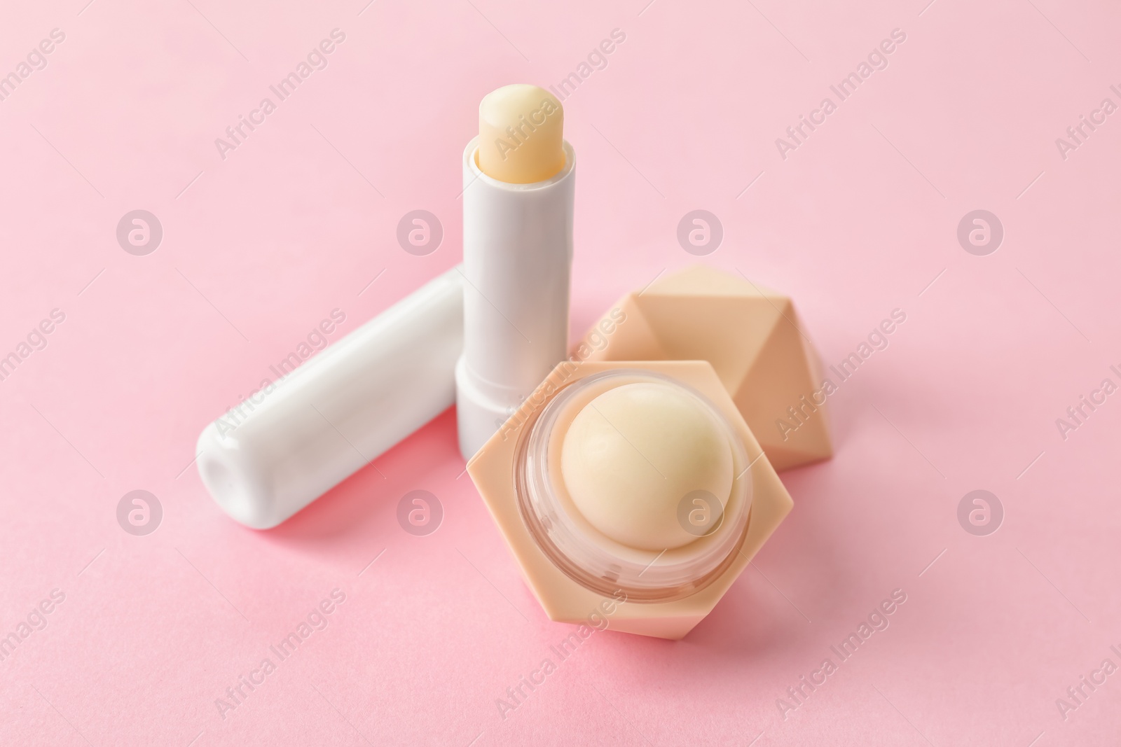 Photo of Hygienic lipstick and balm on color background