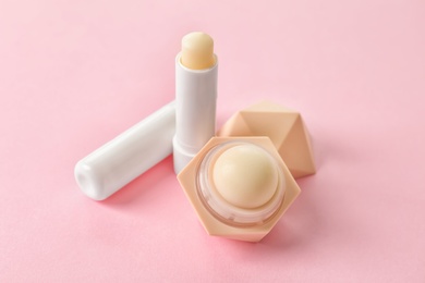 Photo of Hygienic lipstick and balm on color background