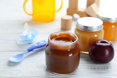 Jars with tasty baby food on table