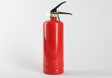 Photo of One red fire extinguisher on white background