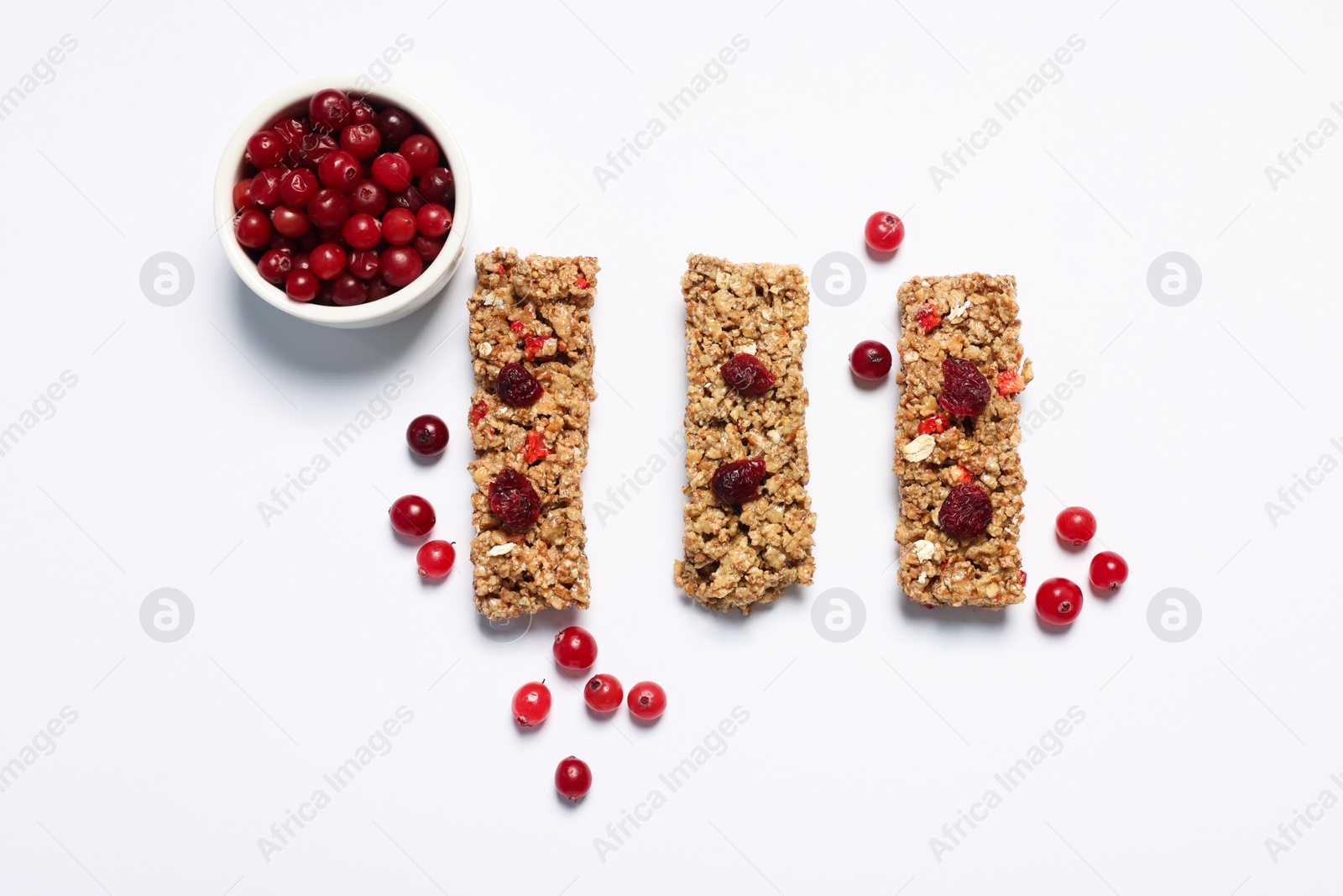 Photo of Tasty granola bars and berries on white background, flat lay