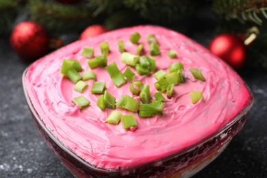 Herring under fur coat salad and Christmas decor on grey table, closeup. Traditional Russian dish