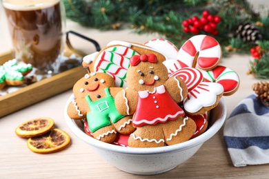 Photo of Delicious Christmas cookies in bowl on wooden table
